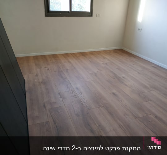 רצפת פרקט עץ חום בחדר ריק עם קיר בהיר